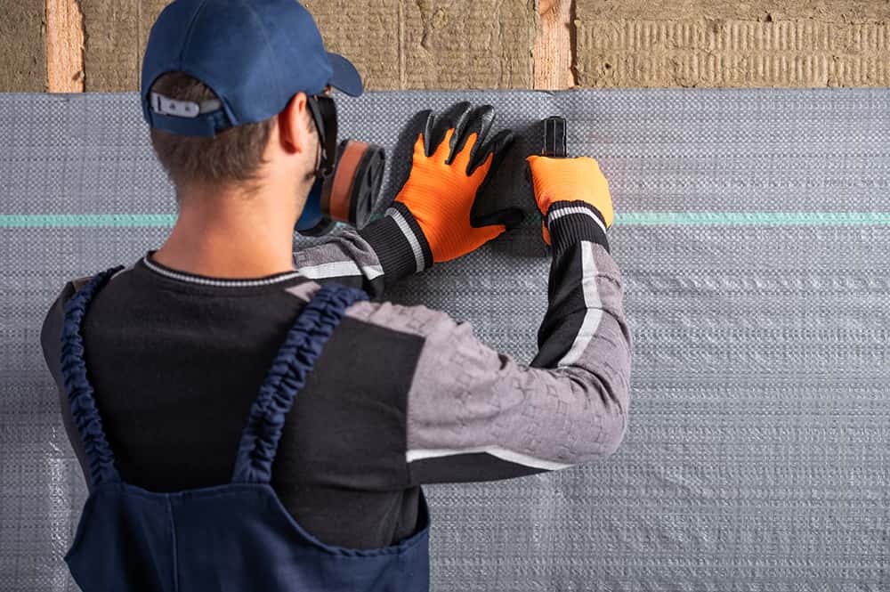 Vapor barrier being mounted by a worker.