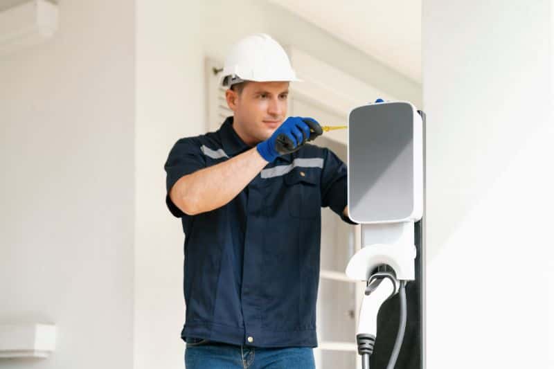 Electrician providing maintenance to a home EV charger.