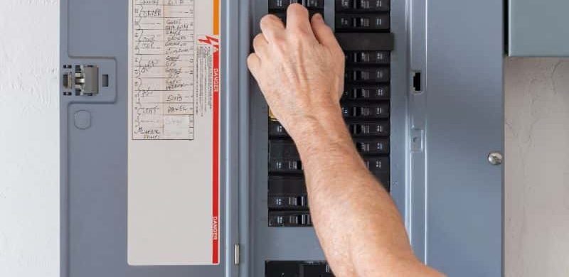 Electrician resetting an electrical panel