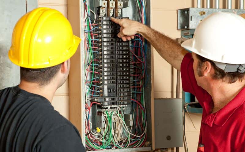 Qualified electricians replacing a circuit breaker