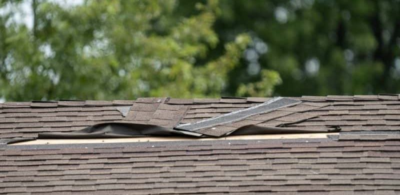 Damaged shingles being replaced by roofer