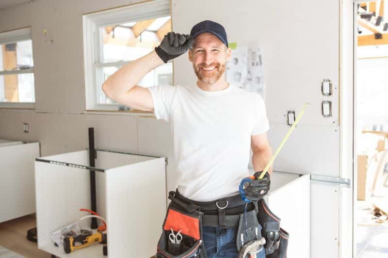 Smiling contractor installing new kitchen upgrades