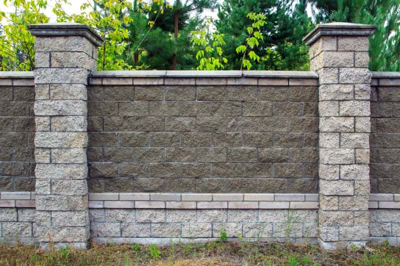 Gray stone fence with concrete on a high-end property