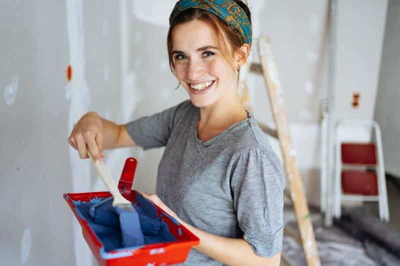 Female enjoying painting house walls