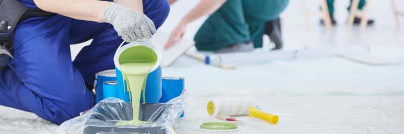 Professional painter preparing paint in tray