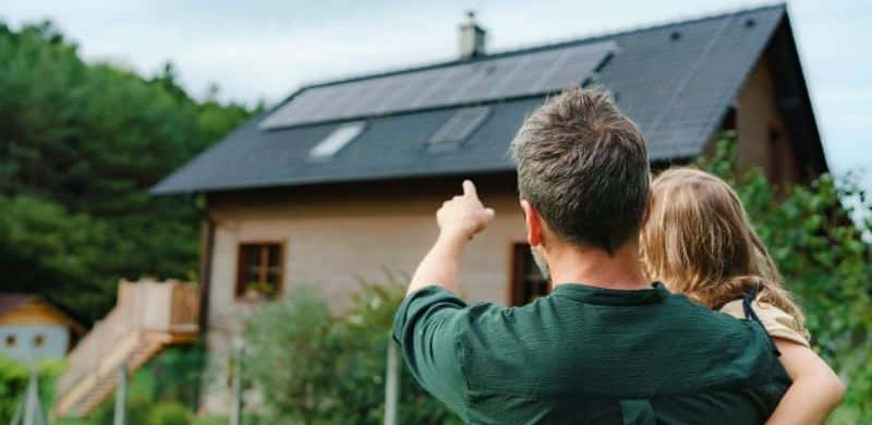 Father showing solar panels on the roof to his daughter