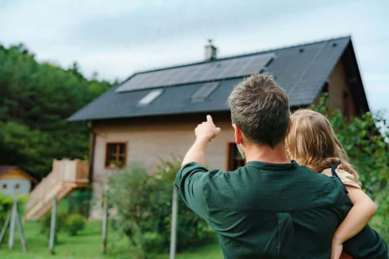 Father showing solar panels on the roof to his daughter